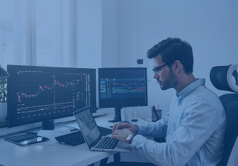 workplace-trader-young-bearded-trader-wearing-eyeglasses-using-his-laptop-while-sitting-office